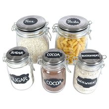 a group of glass jars with labels with text: 'Rice Pasta SUGAR COCOA BUCKWHEAT SUGAR COCOA BUCKWHEAT'