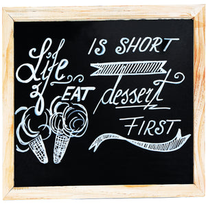 a chalkboard with a sign with text: 'IS SHORT EAT FIRST'
